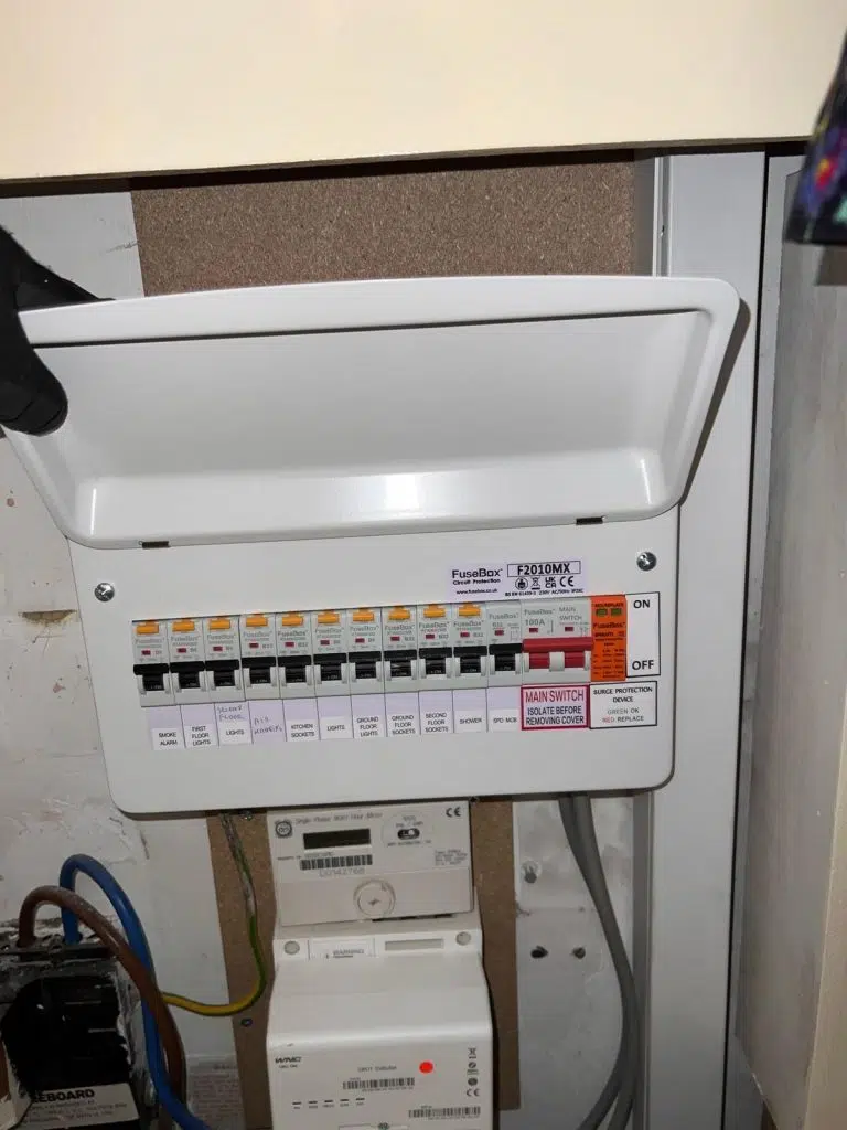 NICEIC electrician wiring new consumer unit during fuse board replacement in Islington